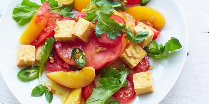Salat mit Tomaten. Würziger Salat mit Tomaten, Rucola, Pfirsich und Tofu