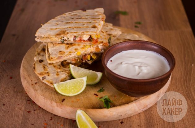 Quesadillas mit Hühnchen-, Mais- und Tomatensalsa, serviert mit Sauerrahm oder Guacamole-Sauce