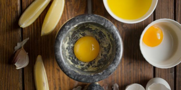 So kochen Sie Austernpilze im Teig mit Aioli: Reiben Sie den Knoblauch mit Eigelb und Salz ein