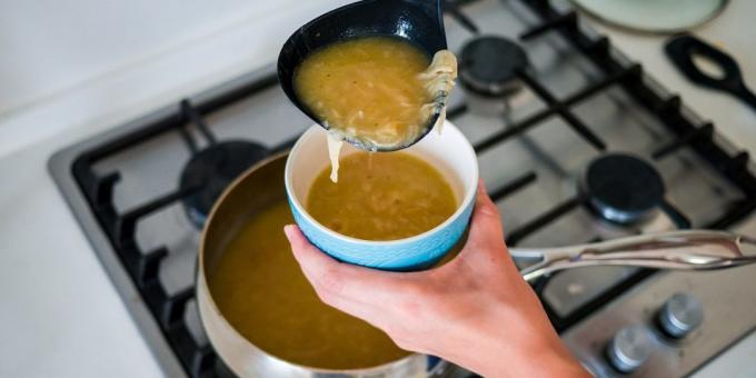 Gießen Sie die Zwiebelsuppe in einem Keramiktopf