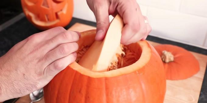 Wie man einen Kürbis für Halloween mit den Händen schneiden: das Fruchtfleisch herausnehmen