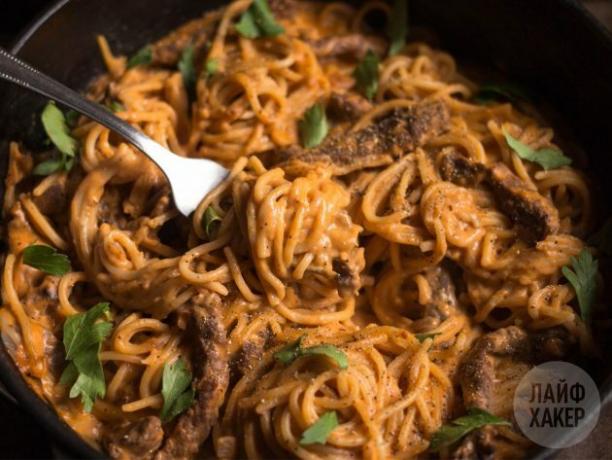 Nudeln mit Rindfleisch in Tomaten-Sahne-Sauce, bestreut mit Petersilie und Pfeffer