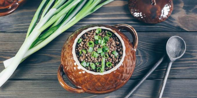 Buchweizen mit Hühnchen und Pilzen in Töpfen